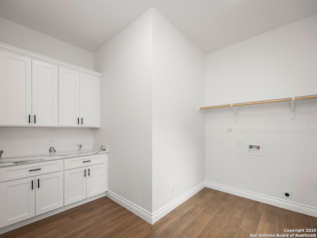 washroom featuring cabinet space, dark wood finished floors, baseboards, and hookup for a washing machine