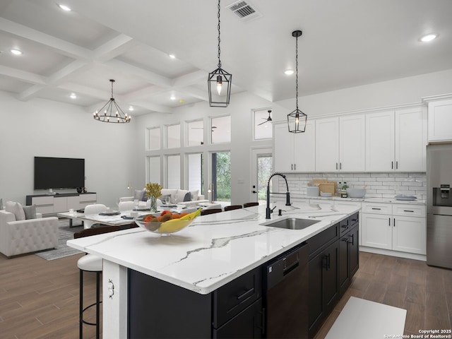kitchen featuring open floor plan, visible vents, a sink, and stainless steel refrigerator with ice dispenser