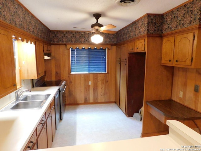 911 Austin, Sabinal, TX 78881 - kitchen with light floors, under cabinet range hood, ceiling fan, a sink, and stainless steel appliances