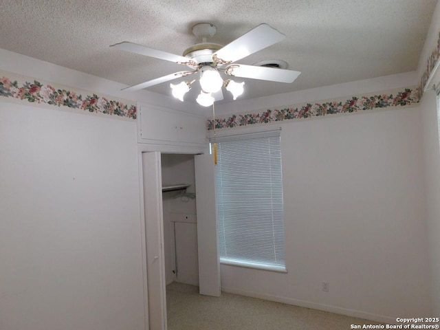 911 Austin, Sabinal, TX 78881 - unfurnished room featuring light colored carpet, a textured ceiling, baseboards, and a ceiling fan