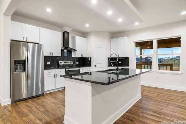 kitchen featuring stainless steel appliances, tasteful backsplash, wall chimney range hood, white cabinetry, and baseboards
