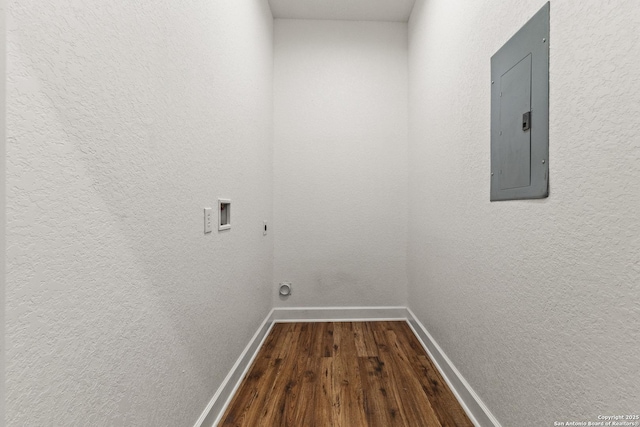 laundry area with electric panel, laundry area, dark wood-style flooring, washer hookup, and baseboards