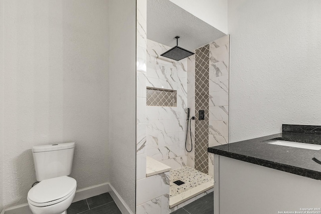full bath featuring toilet, a marble finish shower, a sink, baseboards, and tile patterned flooring