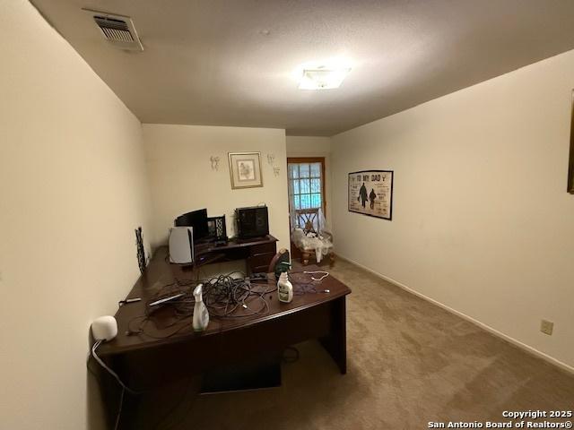 office space with baseboards, visible vents, and carpet