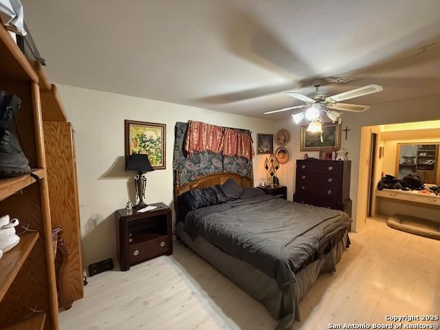 bedroom with a ceiling fan and light wood-style floors