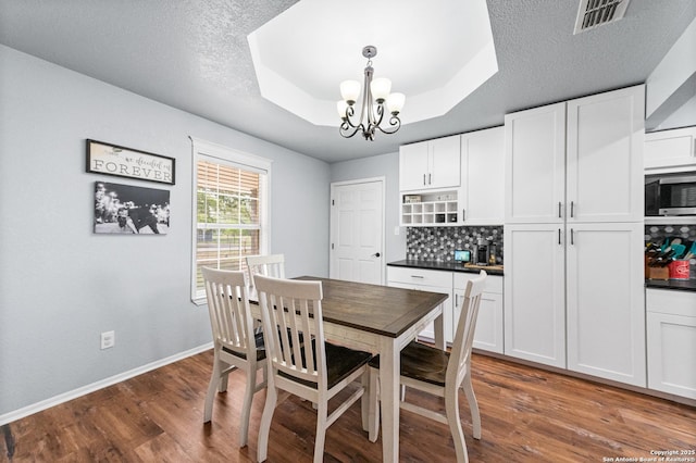 503 Lower Lacoste, Castroville, TX 78009 - dining room featuring a tray ceiling, an inviting chandelier, visible vents, and dark wood-type flooring
