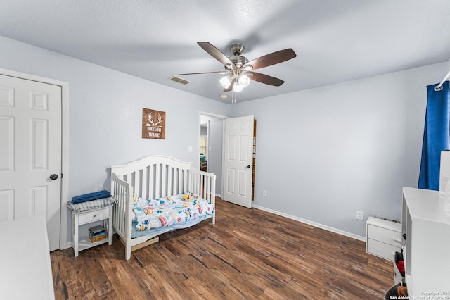 503 Lower Lacoste, Castroville, TX 78009 - bedroom featuring a crib, baseboards, visible vents, and wood finished floors