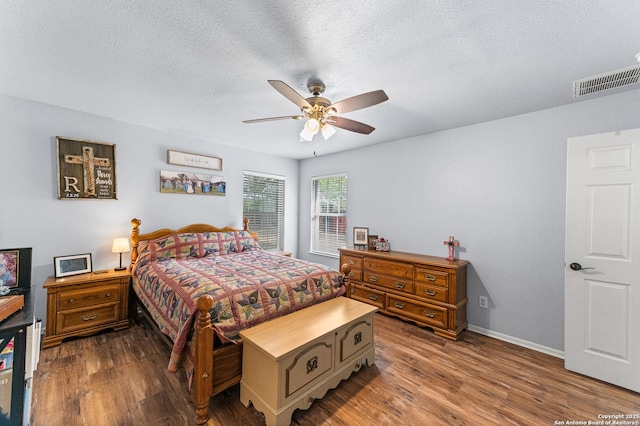503 Lower Lacoste, Castroville, TX 78009 - bedroom featuring a textured ceiling, baseboards, visible vents, and wood finished floors