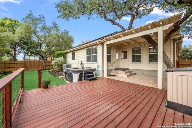 deck with a hot tub, a fenced backyard, and central air condition unit
