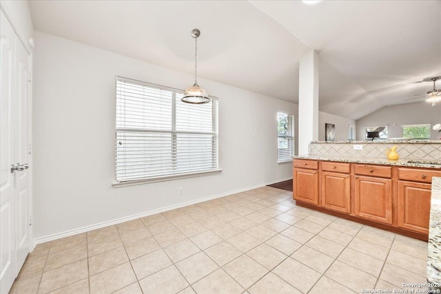 kitchen featuring lofted ceiling, backsplash, ceiling fan, and plenty of natural light