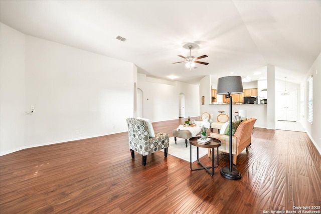 living area with wood finished floors, visible vents, baseboards, ceiling fan, and lofted ceiling