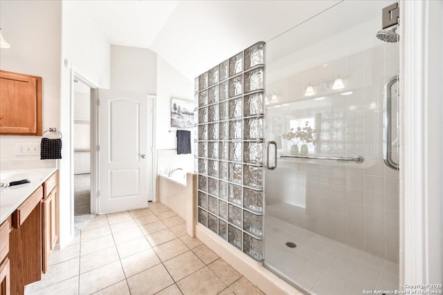 full bathroom featuring a stall shower, tile patterned flooring, a garden tub, vanity, and vaulted ceiling
