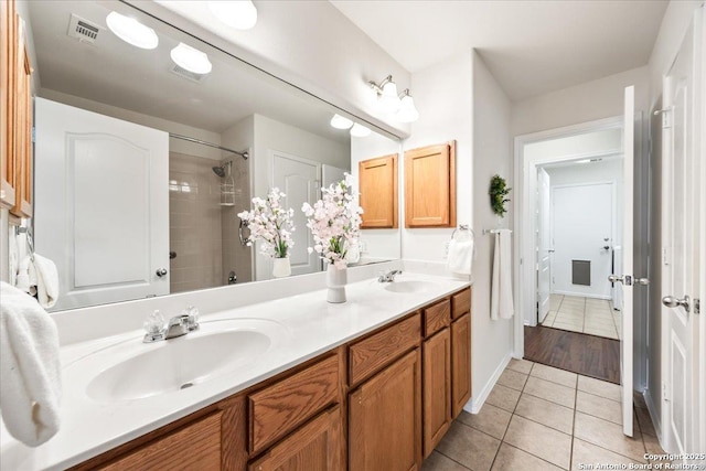 full bath with tile patterned flooring, visible vents, a sink, and double vanity
