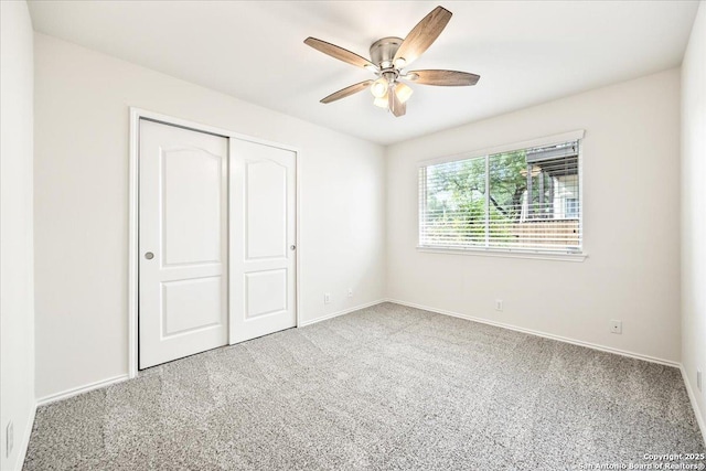 unfurnished bedroom featuring baseboards, carpet flooring, a closet, and a ceiling fan