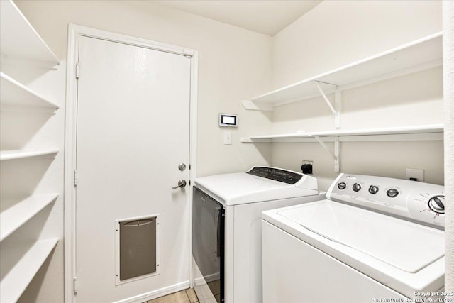laundry room featuring laundry area, washer and clothes dryer, baseboards, and light tile patterned floors