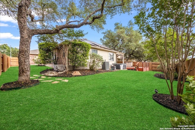 view of yard with central AC and a fenced backyard