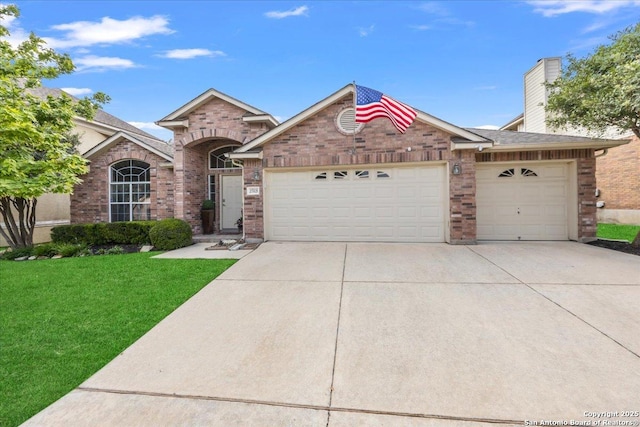 single story home with a garage, a chimney, a front lawn, concrete driveway, and brick siding