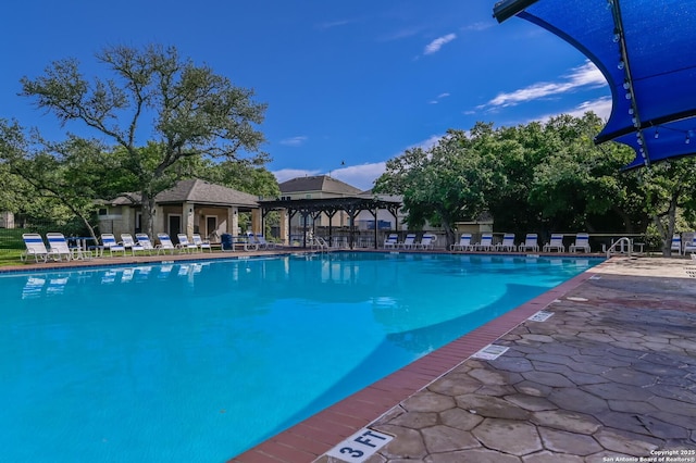 community pool with a gazebo and a patio