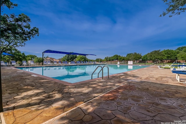 community pool featuring a patio area and fence