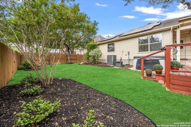 view of yard featuring central air condition unit, a wooden deck, and a fenced backyard
