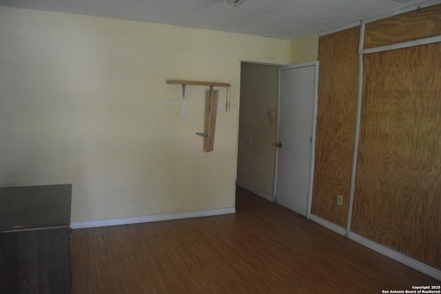 unfurnished bedroom with baseboards, a closet, and wood finished floors