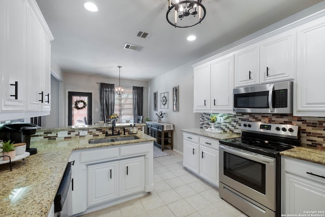190 Da Vinci, San Antonio, TX 78258 - kitchen featuring appliances with stainless steel finishes, a sink, a chandelier, tasteful backsplash, and recessed lighting