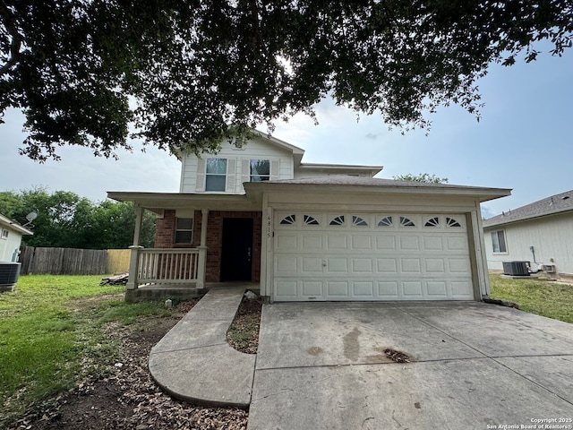 traditional-style house with a porch, brick siding, concrete driveway, a front yard, and central AC unit