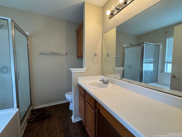 bathroom featuring a shower stall, vanity, toilet, and wood finished floors