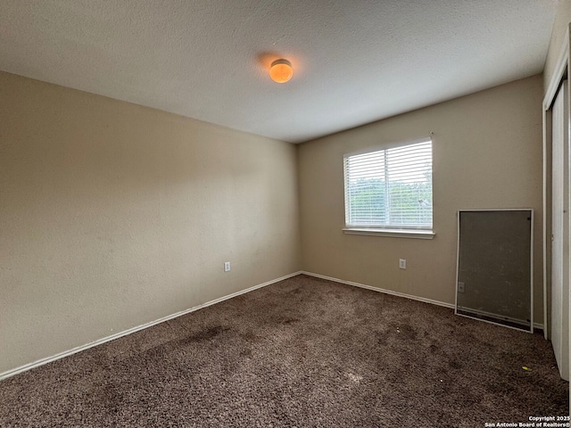 empty room featuring carpet and baseboards