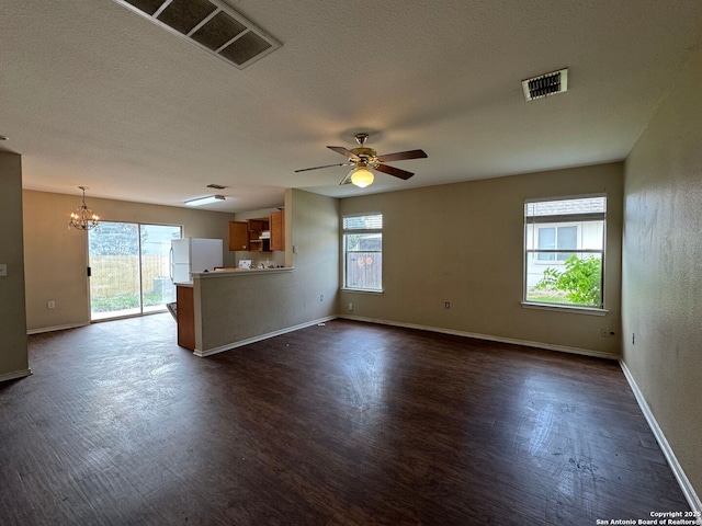 unfurnished living room featuring visible vents, dark wood-style flooring, and ceiling fan with notable chandelier