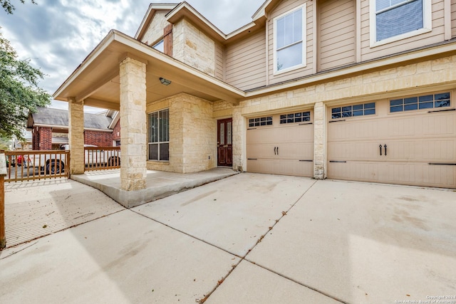 10603 Catfish Ln, San Antonio, TX 78224 - view of exterior entry featuring a garage, concrete driveway, and stone siding