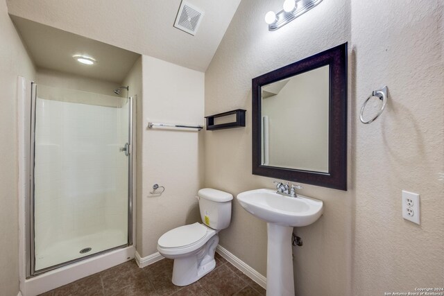 10603 Catfish Ln, San Antonio, TX 78224 - bathroom featuring toilet, tile patterned flooring, a shower stall, and baseboards