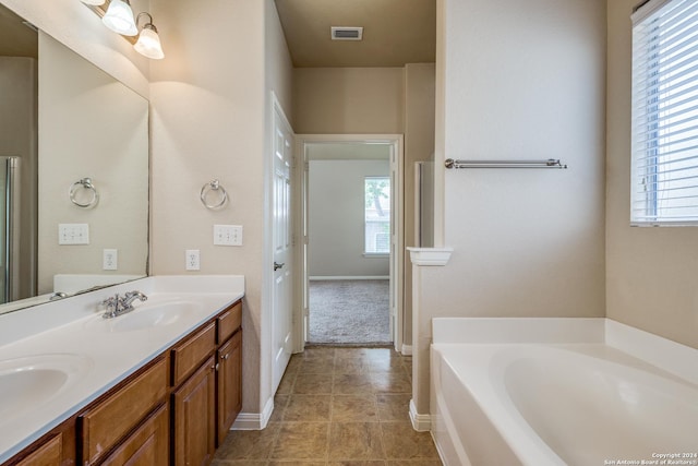 10603 Catfish Ln, San Antonio, TX 78224 - full bathroom featuring plenty of natural light, a garden tub, double vanity, and baseboards