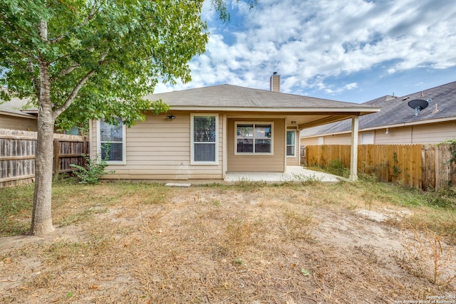 10603 Catfish Ln, San Antonio, TX 78224 - back of house featuring a chimney, a fenced backyard, and a patio area
