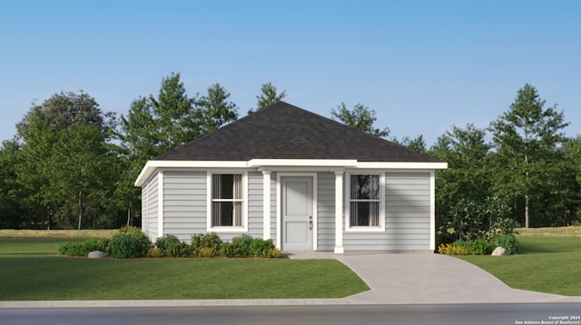 view of front of house with roof with shingles and a front yard