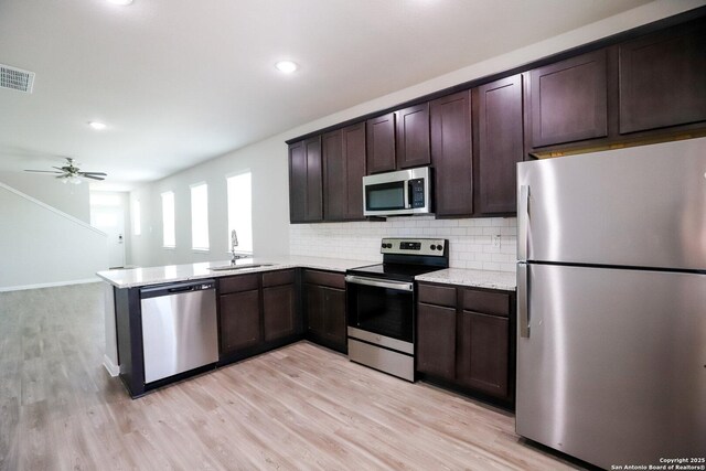 236/238 Joseph Cir, Cibolo, TX 78108 - kitchen featuring a sink, dark brown cabinetry, backsplash, light wood-style floors, and stainless steel appliances