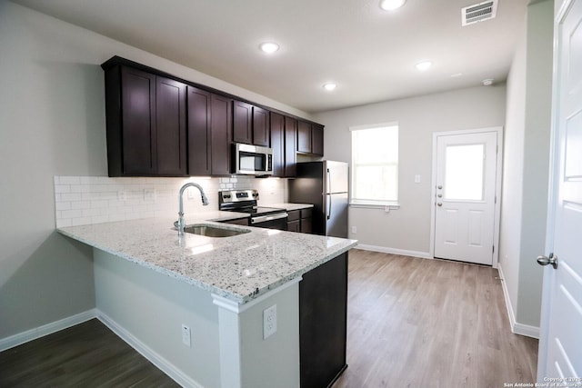 236/238 Joseph Cir, Cibolo, TX 78108 - kitchen with appliances with stainless steel finishes, dark brown cabinets, visible vents, a sink, and light wood-type flooring