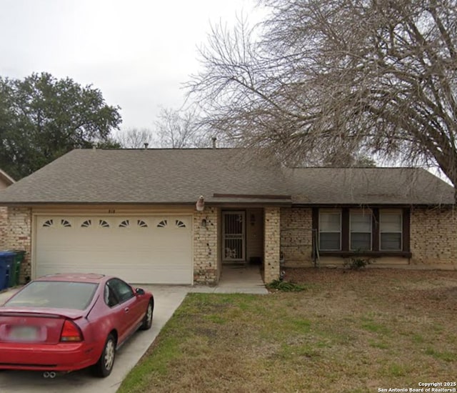 ranch-style house featuring an attached garage, a shingled roof, brick siding, and driveway