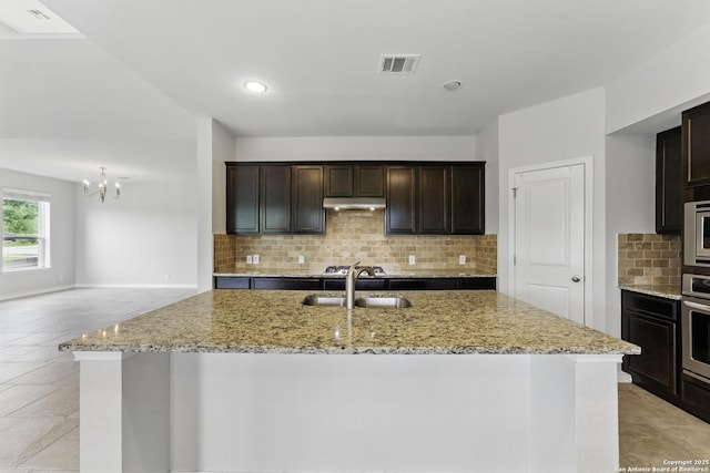 14626 Costa Leon, San Antonio, TX 78245 - kitchen with an inviting chandelier, a sink, visible vents, backsplash, and light stone counters