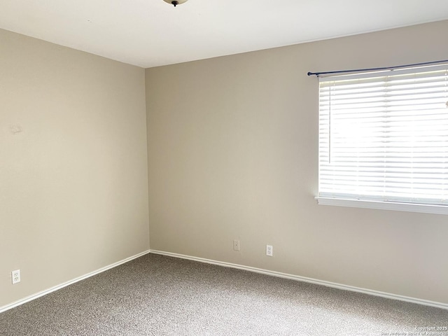 carpeted empty room with plenty of natural light and baseboards