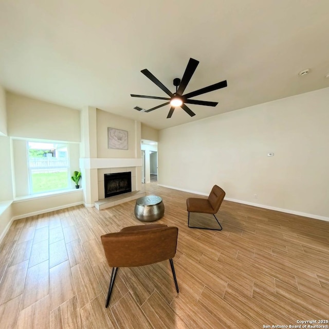 13243 Larkfield, San Antonio, TX 78233 - living room featuring a ceiling fan, baseboards, light wood finished floors, and a tiled fireplace