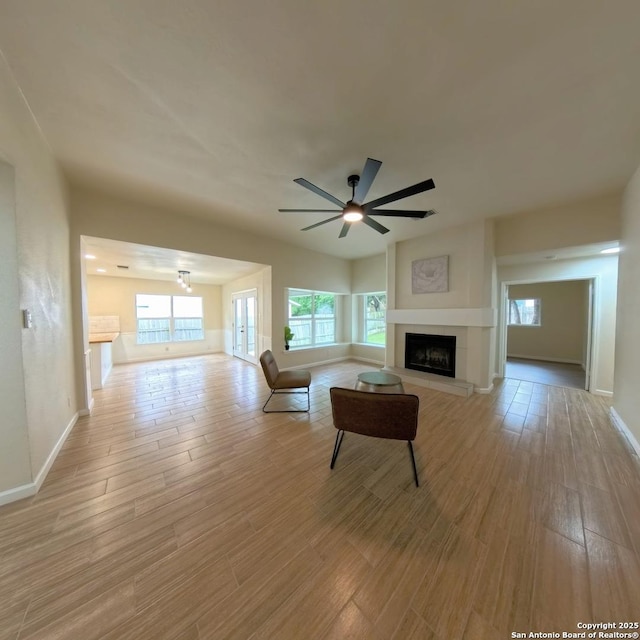 13243 Larkfield, San Antonio, TX 78233 - living area featuring baseboards, ceiling fan, a tiled fireplace, and light wood-type flooring