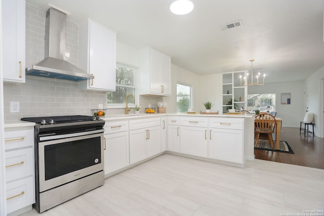 308 Andrews, San Antonio, TX 78209 - kitchen with a peninsula, an inviting chandelier, a sink, wall chimney exhaust hood, and stainless steel range with gas cooktop