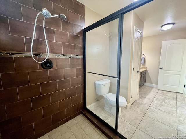 bathroom with tile patterned floors, vanity, toilet, and tiled shower