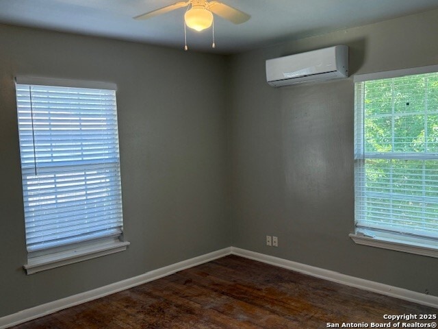 306 Lemur Dr, San Antonio, TX 78213 - spare room featuring baseboards, dark wood-style flooring, ceiling fan, and a wall mounted AC