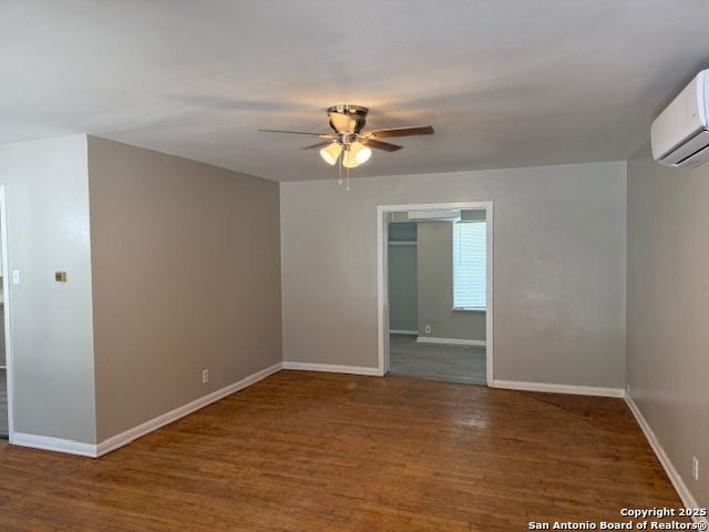 306 Lemur Dr, San Antonio, TX 78213 - empty room with a wall mounted AC, baseboards, a ceiling fan, and wood finished floors