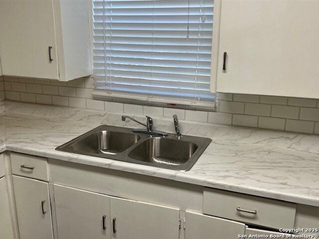 306 Lemur Dr, San Antonio, TX 78213 - kitchen with a sink, white cabinetry, light countertops, and backsplash