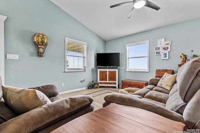 living area featuring carpet flooring, a wealth of natural light, vaulted ceiling, and ceiling fan