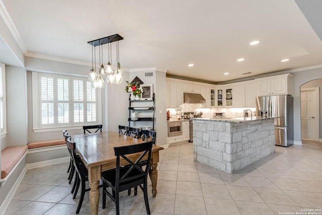 dining space featuring crown molding, light tile patterned flooring, arched walkways, and recessed lighting