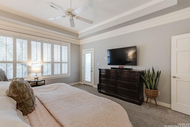 carpeted bedroom with ceiling fan, baseboards, a raised ceiling, and ornamental molding